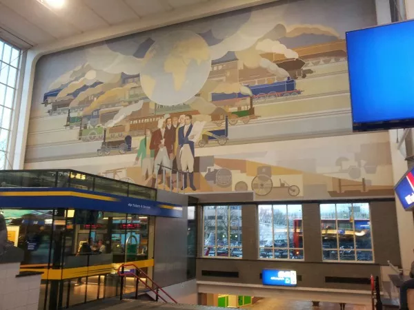 Afbeelding uit: november 2012. Een van de wandschilderingen van Peter Alma, 20 x 9 meter groot. De mannen zijn spoorwegingenieurs; achter hen treinen uit hun tijdperken.

Via de trap kunnen reizigers bij de tramhaltes komen, die zich op polderniveau bevinden.