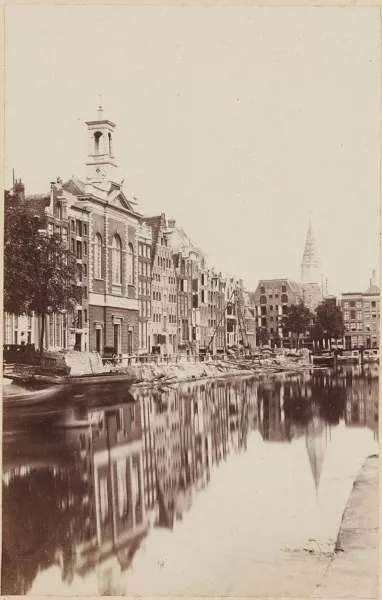 Afbeelding uit: Circa 1863. Met torentje op de voorgevel. De toren op de achtergrond is de destijds enige toren van de Posthoornkerk.
